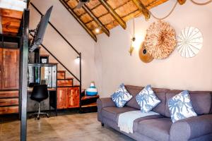 a living room with a couch and a staircase at Little Orvyll's Studio- Near Kruger National Park, you can add up to six guests at our Larger Property Croc Orvyll's Kruger Lodge and all stay in one location in Marloth Park