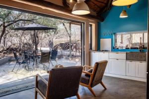 a kitchen with a table and chairs and a zebra outside at Little Orvyll's Studio- Near Kruger National Park, you can add up to six guests at our Larger Property Croc Orvyll's Kruger Lodge and all stay in one location in Marloth Park