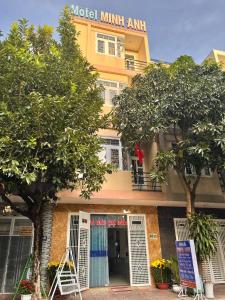 a yellow building with trees in front of it at Nhà Minh Anh in Vung Tau