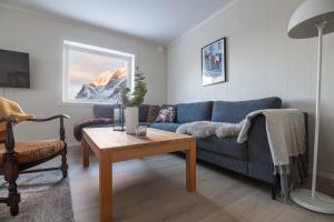 a living room with a blue couch and a table at Valen House, Reine in Reine