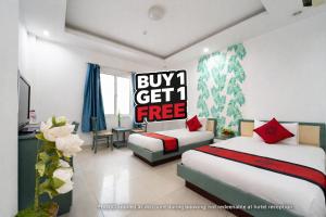 a hotel room with two beds and a buy get free sign at Collection O Cozy 5 Hotel - Near SECC in Ho Chi Minh City