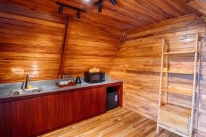 a kitchen with wooden walls and a counter with a microwave at The Dewi Tasik Kintamani Cabin and Villa in Kubupenlokan +128 photos