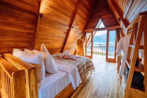 a bedroom with a bed in a wooden cabin at The Dewi Tasik Kintamani Cabin and Villa in Kubupenlokan