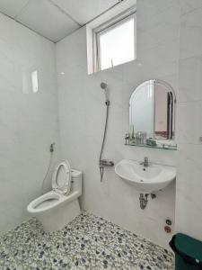 a bathroom with a toilet and a sink and a mirror at Nhà Minh Anh in Vung Tau