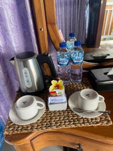 a table with two cups and two bottles of water at De La Sierra in Munduk