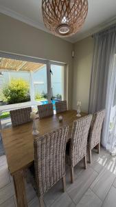 a dining room with a wooden table and chairs at Villa on Private Estate with Pool in Hermanus