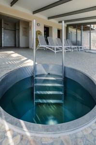 a pool of water with chairs in a building at Sassnitz - Kamin, Meerblick, Sauna, Fitness - FeWo frische Brise in Sassnitz