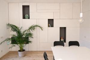 a dining room with a table and chairs and a plant at STUDIO 14 - apt design con terrazza sul fiume - 2 biciclette incluse - vicino al centro in Treviso