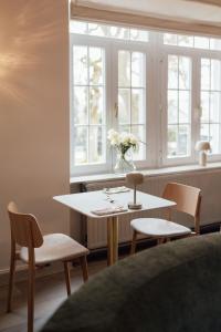 a table and chairs in a room with a window at Hotel Château Palacio in Fauvillers