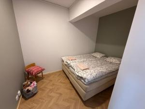a small bedroom with a bed and a chair at Central Kauppakatu Apartment in Joensuu