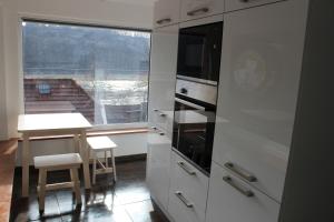 a kitchen with white cabinets and a table and a window at Bungalow Schönblick in Pirna