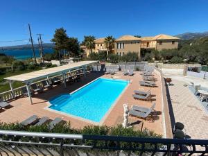 a swimming pool with lounge chairs and a resort at RESIDENTS IONIAN (BED AND BREAKFAST) in Argostoli