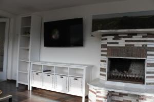 a living room with a fireplace with a flat screen tv at Bungalow Schönblick in Pirna +6 photos