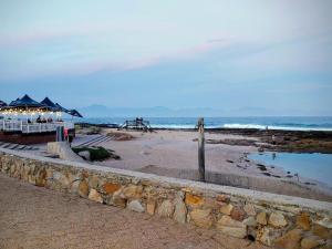 a beach with a bar and the ocean at Lilla-Bett Self Catering Mossel Bay in Mossel Bay