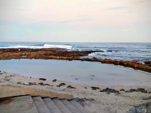 a pool of water on a beach with the ocean at Lilla-Bett Self Catering Mossel Bay in Mossel Bay +19 photos