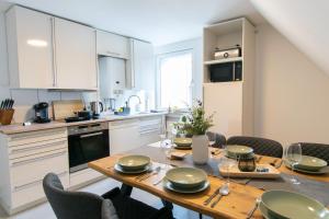 a kitchen with a wooden table with chairs and a dining room at EasyGoing Switch Streaming schönes Apartment 6 Personen in Arnsberg +17 photos