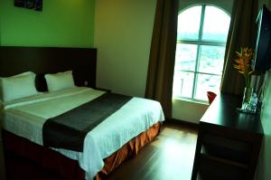 Postel nebo postele na pokoji v ubytování Lintas Plaza Hotel
