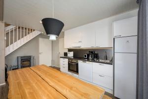a kitchen with white cabinets and a wooden table at Villa Breikki Himos - Alpha & Bravo Incl WiFi, Sauna, Jacuzzi for extra fee in Jämsä +30 photos