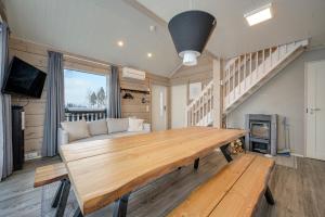 a large wooden table in a living room with a couch at Villa Breikki Himos - Alpha & Bravo Incl WiFi, Sauna, Jacuzzi for extra fee in Jämsä