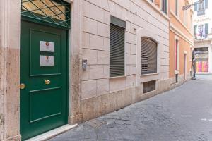 a green door on the side of a building at Maison dei Greci in Rome