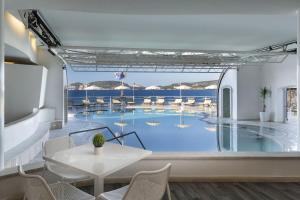 a view of a pool from a restaurant with a table and chairs at El Faro Hotel & Spa in Porto Conte