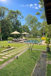 a tree in the middle of a yard with a pool at Maho Boutique Hotel in Anuradhapura