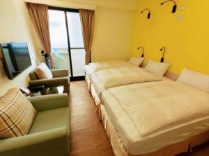 a bedroom with a bed and a couch and a tv at Donghae13.8 in Longjing
