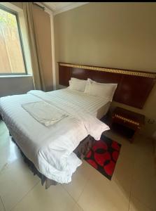 a bedroom with a large bed with white sheets at Sefitel in Lubumbashi