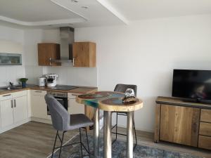 a kitchen with a table and chairs and a television at Meerblick 1 in Sierksdorf