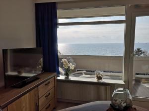 a bedroom with a large window with a view of the ocean at Meerblick 1 in Sierksdorf +15 photos
