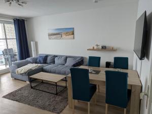 a living room with a blue couch and a table at Fabelhaft am Meer in Timmendorfer Strand