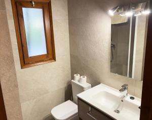 a bathroom with a toilet and a sink and a mirror at Calsina Baix 2H in Pals