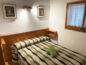 a bedroom with a bed with a green pillow on it at Calsina Baix 2H in Pals