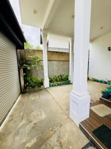 an empty garage with a white column in front of a house at Akshi Hostel in Kandy
