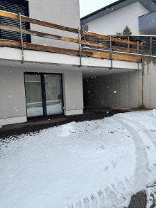 a snow covered yard in front of a building at Apartment Leitner in Haiming