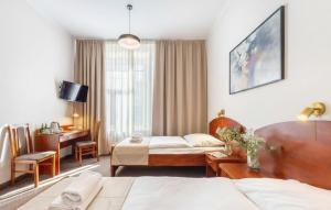 ein Hotelzimmer mit Bett und Schreibtisch in der Unterkunft Hotel Lothus in Breslau + 72 Fotos