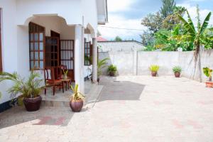a patio with potted plants and a building at Arusha Oasis Executive Residence in Arusha
