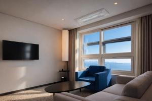 a living room with a couch and a chair and a tv at Sky Stay in Incheon