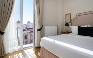 a bedroom with a white bed and a large window at EV 11 Athens in Athens