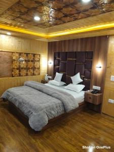 a bedroom with a large bed with white pillows at Hotel Pahalgam view in Pahalgām