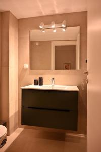 a bathroom with a sink and a mirror at Brand New! Fresh Kolonaki Studio in Athens