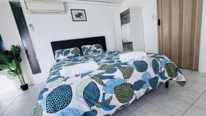 a bedroom with a bed with a colorful comforter and pillows at Logement - maison d'hôtes Communay in Communay