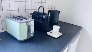 a kitchen counter with a toaster and a cup on it at Logement - maison d'hôtes Communay in Communay