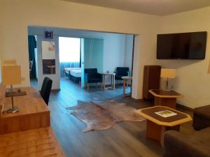 a living room with a couch and a living room with a table at Land-gut-Hotel Zum alten Forsthaus - Aufladestation für Elektroautos in Hürtgenwald