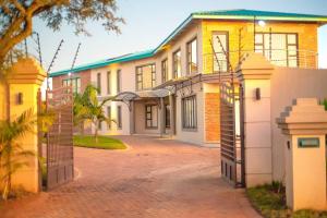 a house with a driveway in front of it at Nkandla Resort in Bulawayo