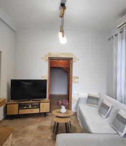 a living room with a couch and a flat screen tv at Koskinou Residence in Koskinou