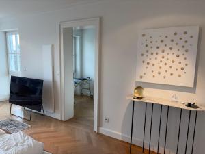 a living room with a television and a painting on the wall at Herrenhaus - Starnberger See - Ammerland in Münsing
