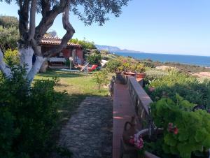 a garden with a house and a fence with flowers at Residence Costa Caddu San Teodoro in Porto Ottiolu