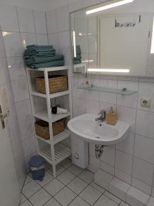 a white bathroom with a sink and a mirror at Fabelhaft am Meer in Timmendorfer Strand