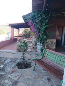 a bench sitting in front of a building with flowers at Residence Costa Caddu San Teodoro in Porto Ottiolu +11 photos